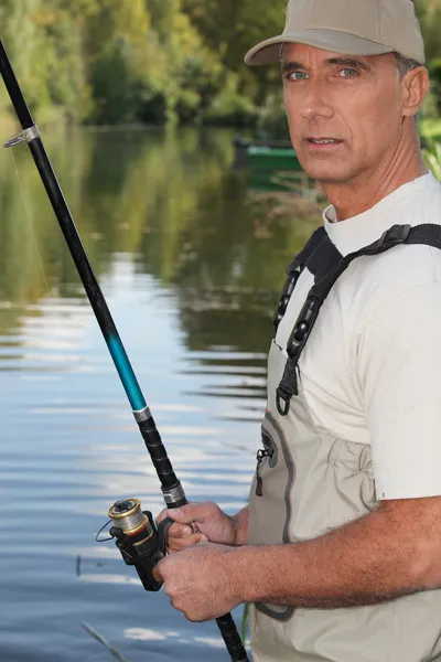 50 let starý muž rybolov na okraji řeky — Stock fotografie