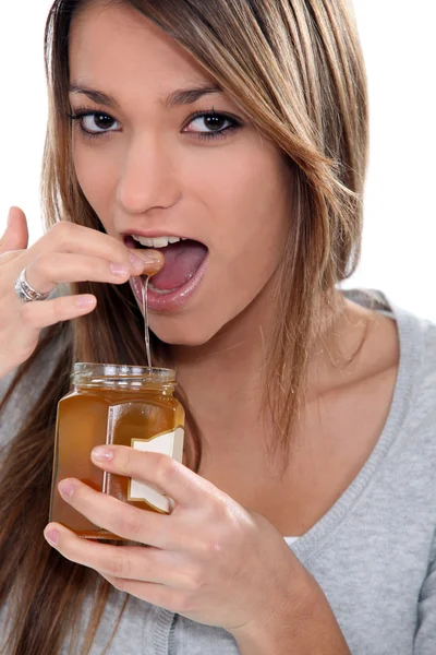 Mädchen isst Honig — Stockfoto