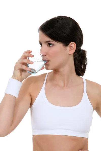 Mulher bebendo água no ginásio — Fotografia de Stock