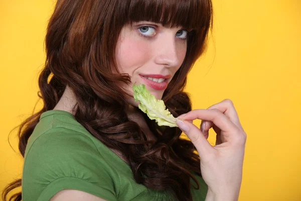 Woman with a salad leaf — Stock Photo, Image