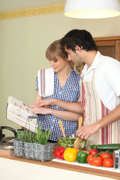 Couple following a recipe book — Stock Photo, Image