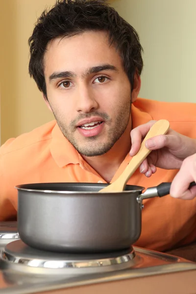 En man tittar på någon matlagning — Stockfoto