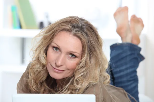 Blonde vrouw op laptop — Stockfoto