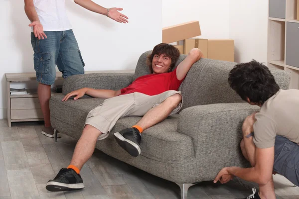 Трое мужчин раскладывают мебель — стоковое фото