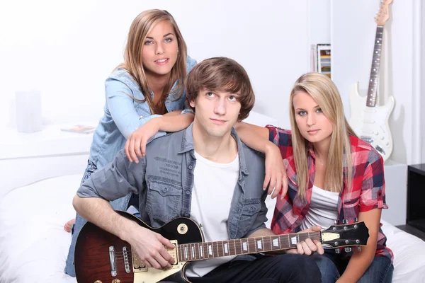 Підліток з гітарою сидів з друзями — стокове фото