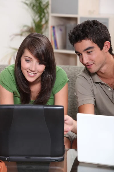 Giovane coppia con i loro computer portatili — Foto Stock