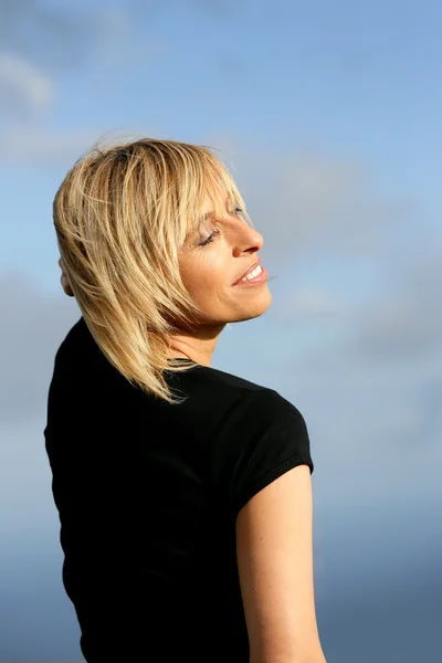 Blond woman stood outdoors on a sunny day — Stok fotoğraf