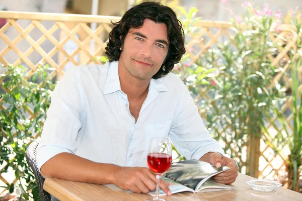 Homem desfrutando de um copo de vinho em um café ao ar livre — Fotografia de Stock