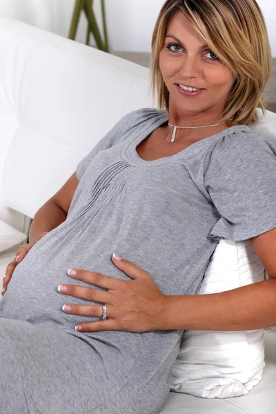 Een zwangere vrouw aan haar maag te raken — Stockfoto