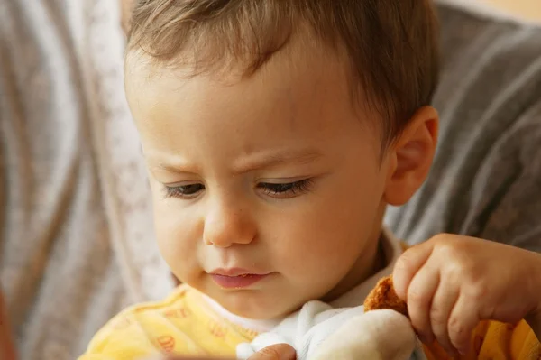 Маленький ребенок играет с мягкой игрушкой — стоковое фото