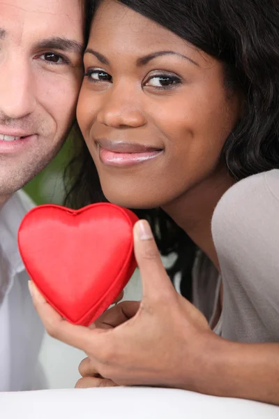 Loving couple holding a heart case — Stock Photo, Image