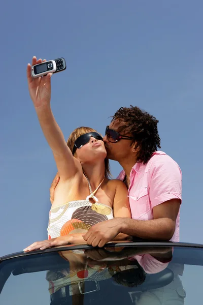 Весела пара в кабріолеті робить фото на мобільному телефоні — стокове фото