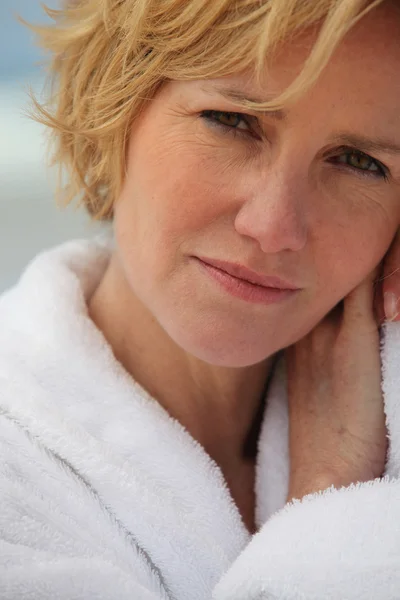 Close-up of blond woman wearing white bathrobe outdoors — Stock Photo, Image