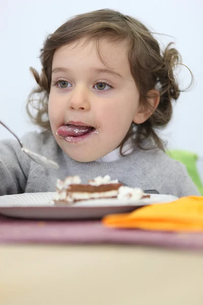 Young girl eating a piece of cake — Stock Photo, Image