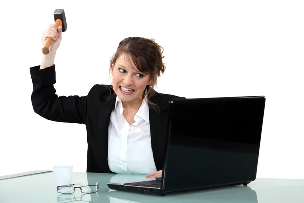 Woman threatening computer with hammer — Stock Photo, Image