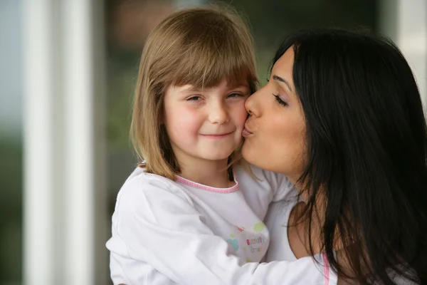 Woman kissing her daughter Stock Photo