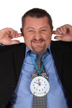 Man blocking his ears because of alarm clock clipart