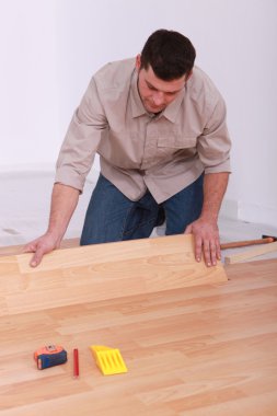 Man installing laminate flooring clipart