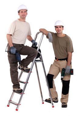 Two workers posing with drills clipart