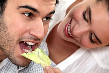 Woman giving her boyfriend a salad clipart