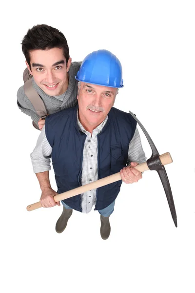 High angle shot of apprentice and senior mentor holding pickaxe — Stock Photo, Image
