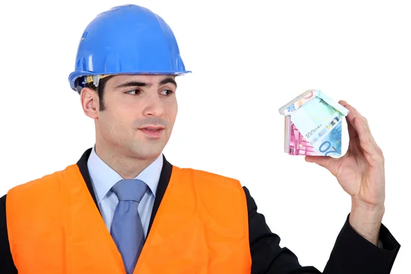 Inspector with a house made of money — Stock Photo, Image