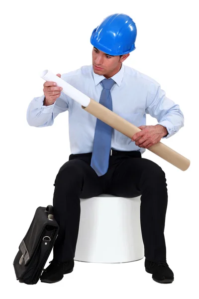 Engineer pulling out a rolled-up drawing out of its protective tube — Stock Photo, Image