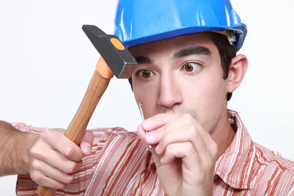 Constructor golpeando clavo con martillo —  Fotos de Stock