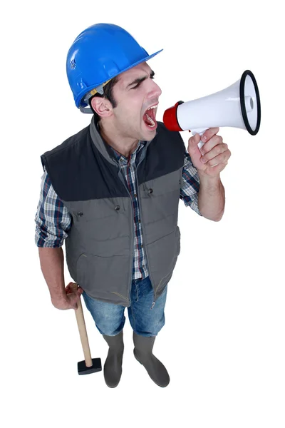 Angry tradesman yelling into a megaphone — Stock Photo, Image