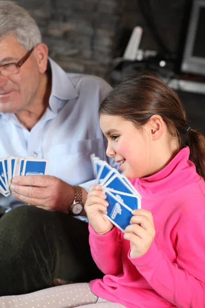 Petite fille jouant aux cartes avec grand-père — Photo