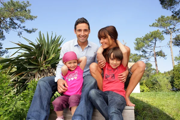 Young family gathered in the garden — Stock Photo, Image