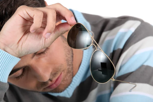 Homem cansado segurando óculos de sol — Fotografia de Stock