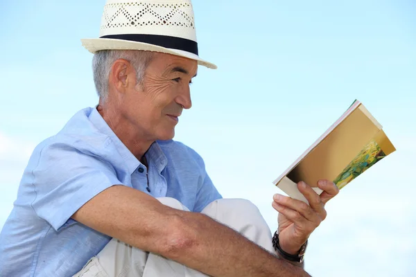 Зрелый мужчина, читающий книгу на улице . — стоковое фото