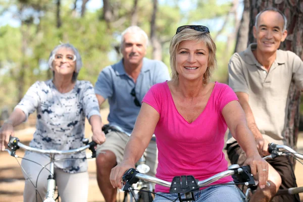Personas mayores montando bicicletas en el parque — Foto de Stock