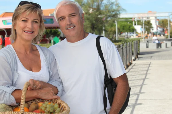 Paar im Urlaub mit einem Obstkorb — Stockfoto