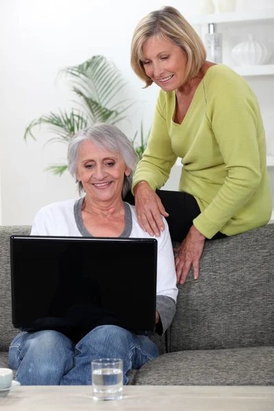 Two senior friends relaxing at home — Stockfoto