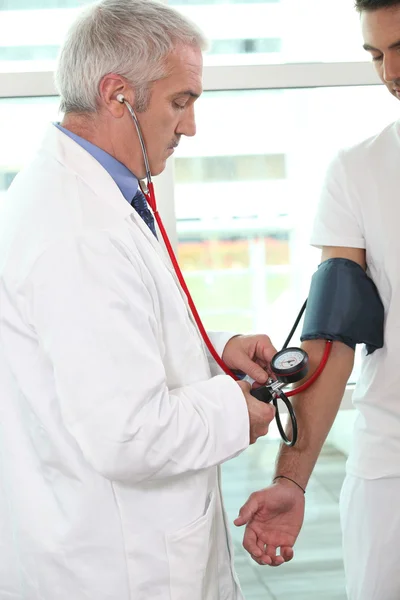 Dokter die de bloeddruk van een patiënt controleert — Stockfoto