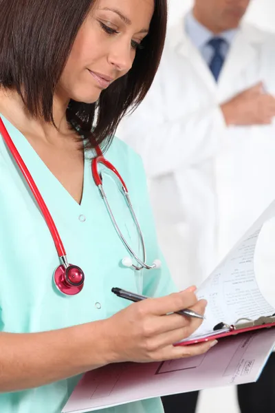 Infirmière en blouse avec un presse-papiers — Photo