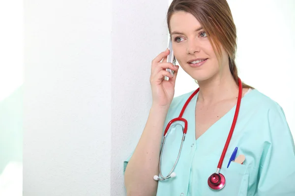 Nurse smiling on phone — Stock Photo, Image