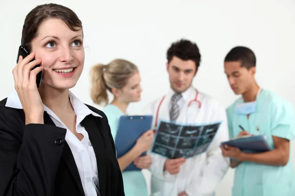 Businesswoman in a hospital talking on her cell — Stock Photo, Image