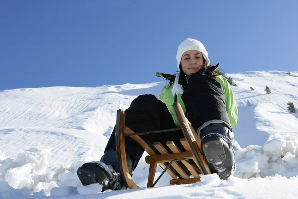 Girl on a sled in mountain — Stock Photo, Image