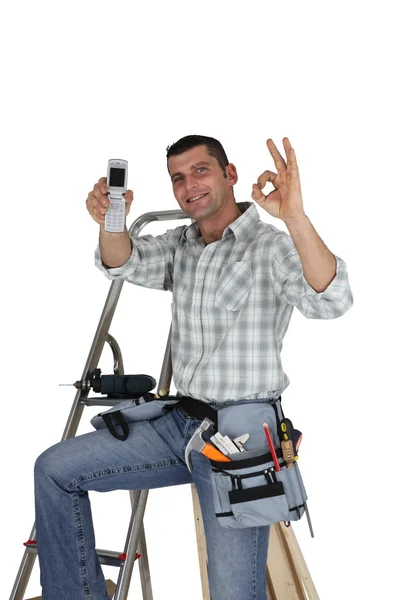Carpenter with mobile giving the OK — Stock Photo, Image