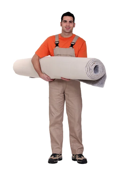 Montador de tapete carregando um rolo de tapete — Fotografia de Stock