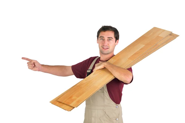 Man carrying laminate flooring and pointing — Stock Photo, Image