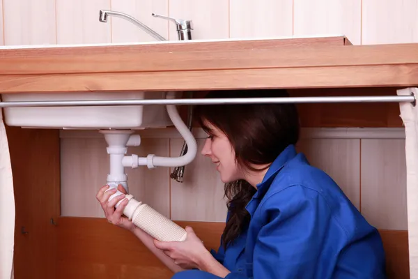 Jonge vrouwelijke leerling loodgieter een wastafel — Stockfoto