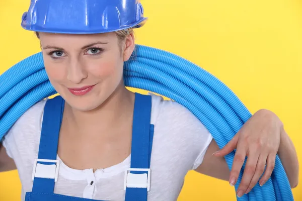 Eine Handwerkerin mit um den Hals gewickelten Schläuchen — Stockfoto