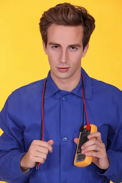 Eletricista segurando um multímetro em torno de seu pescoço — Fotografia de Stock