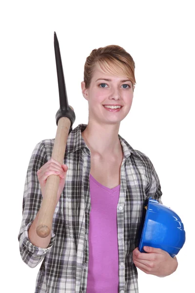 Young female bricklayer posing with pickaxe and hard hat — Stock Photo, Image