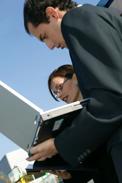 Коллеги с ноутбуком на открытом воздухе — стоковое фото