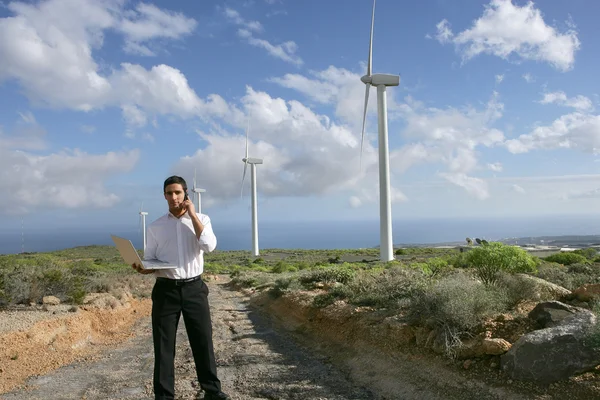 Человек с телефоном и ноутбуком на ветряной электростанции — стоковое фото